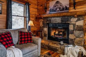 a living room with a fireplace in a log cabin at Lazy Fox Hideout in Sevierville