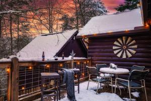 a cabin in the snow with a table and chairs at Lazy Fox Hideout in Sevierville
