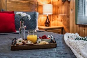 a tray of food and orange juice on a bed at Lazy Fox Hideout in Sevierville
