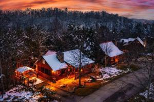 a cabin in the woods with snow on the roof at Lazy Fox Hideout in Sevierville