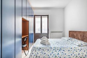 a bedroom with a bed with towels on it at Milan - Bocconi e Navigli - Spacious 3BR Apartment 95 m - Free Parking in Milan