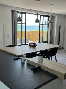 a dining room with two tables and a view of the ocean at Villa, au coeur de Morgat in Crozon