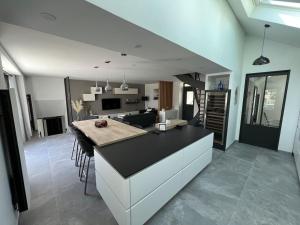 a kitchen and living room with a counter and a table at Villa, au coeur de Morgat in Crozon