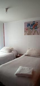 1 dormitorio con 2 camas y un cuadro en la pared en El Rincon de los Poetas, en Nueva Imperial