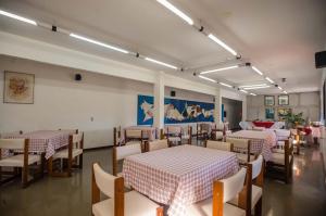 a restaurant with tables and chairs in a room at Alpes Hotel in Venda Nova do Imigrante