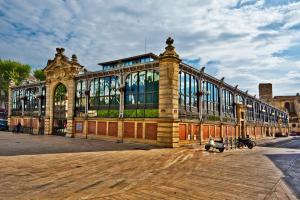 un grand bâtiment avec des fenêtres en verre sur une rue dans l'établissement Appartement calme centre ville à 80m des Halles, à Narbonne