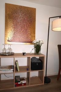 a desk with a lamp and a vase of flowers on it at Julia's Mosel Villa Appartement NICOLAS in Traben-Trarbach