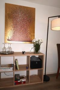 een bureau met een lamp en een vaas met bloemen erop bij Julia's Mosel Villa Appartement NICOLAS in Traben-Trarbach