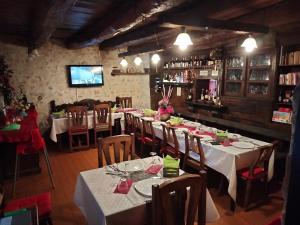 a dining room with tables and chairs and a television at I Casali del Buontempo in Buggiano