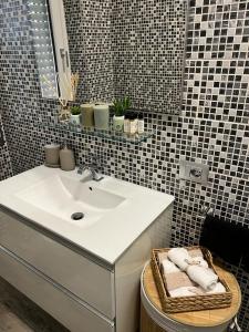 a bathroom with a sink and a basket with towels at Appartamento a Milano, 12 minuti dalla stazione centrale FS in Cinisello Balsamo