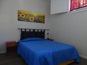 Un dormitorio con una cama azul y una pintura en la pared en Il Gallo, en San Casciano in Val di Pesa