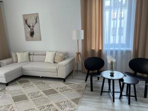 ein Wohnzimmer mit einem Sofa, einem Tisch und Stühlen in der Unterkunft Apartamenty Przy Deptaku in Świnoujście