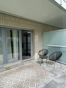 zwei Stühle auf einer Terrasse vor einem Gebäude in der Unterkunft Paris to Bochum, 4 Pers. Apartm. in Bochum