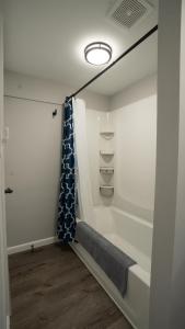 ein Bad mit einer Badewanne und einem Duschvorhang in der Unterkunft Wally's House in Hawley