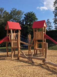 two wooden playground equipment with a slide in a park at Onlycamp Tours Val de Loire in Saint-Avertin