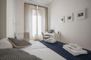 a white bedroom with a bed and a desk at Synagogue Suite-Hosted by Sweetstay in Florence