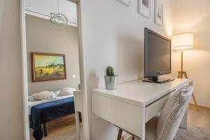 a room with a desk with a television and a bed at Synagogue Suite-Hosted by Sweetstay in Florence