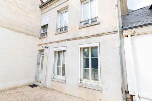 - un bâtiment blanc avec des fenêtres dans l'établissement Gîte d'Artagnan (6 personnes), à Villers-Cotterêts