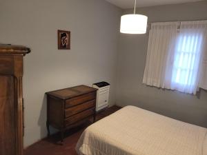 - une chambre avec un lit, une commode et une fenêtre dans l'établissement Casa de pueblo San Mayol, 