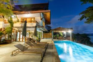 a villa with a swimming pool at night at 悬崖别墅 无边海景 直达海滩 五卧泰式独栋私人泳池别墅 超漂亮日出 in Phuket Town