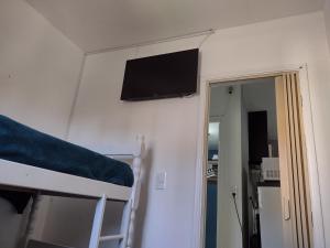 ein Schlafzimmer mit einem Etagenbett und einem Flachbild-TV an der Wand in der Unterkunft Apartamento Pé na Praça Central de Poços de Caldas in Poços de Caldas