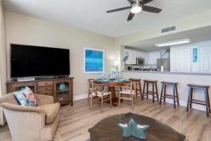 a living room with a television and a table at Stunning Ocean & Sunset Views, Direct Beach Access with 2 King Bedrooms at Panama City Beach, Fl in Panama City Beach