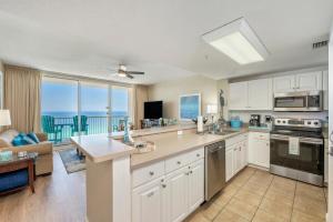 a kitchen with white cabinets and a view of the ocean at Stunning Ocean & Sunset Views, Direct Beach Access with 2 King Bedrooms at Panama City Beach, Fl in Panama City Beach