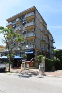 a tall apartment building with a car parked in front of it at Rivazzurra Hotel in Pesaro