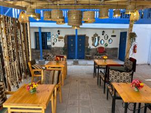un restaurante con mesas y sillas de madera y puertas azules en CASA CRISTOBAL Siete Cuartones CASONA COLONIAL en Cusco