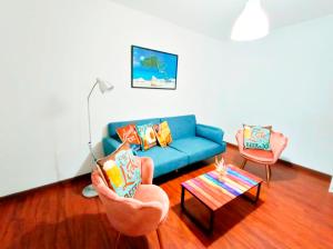 a living room with a blue couch and a table at By Plaza Real Rooms in Barcelona
