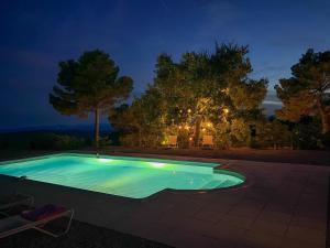 ein Schwimmbad in einem Garten in der Nacht in der Unterkunft Villa "Le Sortilège" vue panoramique et piscine in Tourtour