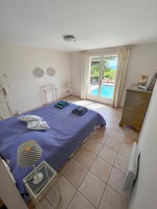 a bedroom with a blue bed and a balcony at Villa "Le Sortilège" vue panoramique et piscine in Tourtour