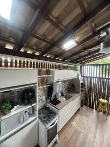 a kitchen with white cabinets and a stove at Village ITACIMIRIM in Camaçari