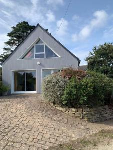 a gray house with a brick driveway at Maison 400m de la plage in Crozon