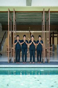 a group of people standing next to a swimming pool at Sitara Weligama in Weligama