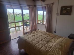 1 dormitorio con 1 cama y balcón con vistas. en Linda casa de campo en Mejia - Arequipa, en Mejia