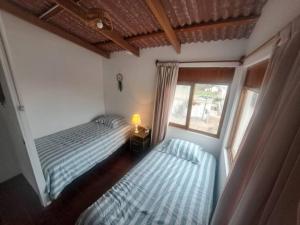 um quarto com 2 camas e uma janela em Linda casa de campo en Mejia - Arequipa em Mejia