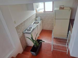 a small kitchen with a sink and a refrigerator at Linda casa de campo en Mejia - Arequipa in Mejia