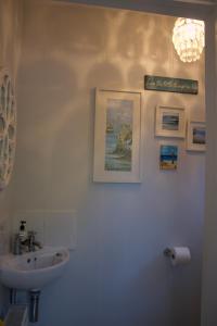 a white bathroom with a sink and a mirror at Cartref, 1860s family home. in Bridgend