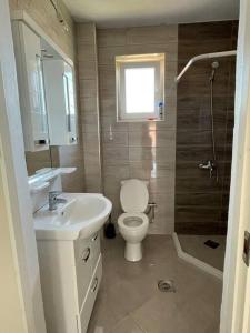 La salle de bains est pourvue de toilettes, d'un lavabo et d'une douche. dans l'établissement Apartment in Mitrovicë, Kosovë, à Kosovska Mitrovica