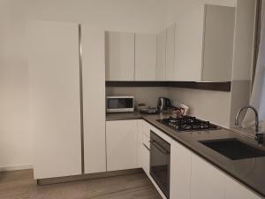 een keuken met witte kasten en een fornuis met oven bij Bergamo Alta Guest House in Bergamo