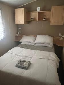 a room with two beds with white sheets at Lisa and Laddy Caravan Hire in Meliden
