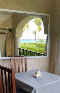 a table with a view of the ocean and palm trees at Departamento frente al mar con dos recámaras y seguridad 24 h a dos cuadras de la Quinta Avenida in Playa del Carmen