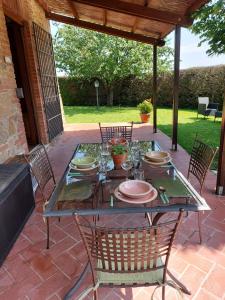 - une table avec des chaises et des assiettes sur la terrasse dans l'établissement Il Tiglio Bianco, à Sienne