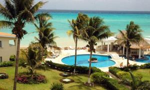 a view of a resort with a swimming pool and the ocean at Departamento frente al mar con dos recámaras y seguridad 24 h a dos cuadras de la Quinta Avenida in Playa del Carmen +9 photos