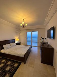 a bedroom with a large bed and a television and aoit at Résidence Le Monaco Sousse in Sousse