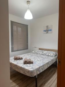 ein Schlafzimmer mit einem Bett mit zwei Handtüchern darauf in der Unterkunft CAROLINAS SUIT in Alicante
