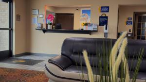 una sala d'attesa con una sedia in pelle in una sala d'attesa di Days Inn & Suites by Wyndham Kaukauna WI a Kaukauna