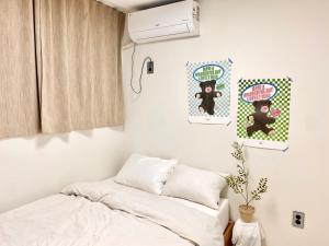 Habitación pequeña con cama y ventana en Maison Apartment Residense, en Seúl