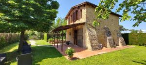 - un bâtiment en pierre avec une terrasse couverte dans une cour dans l'établissement Il Tiglio Bianco, à Sienne